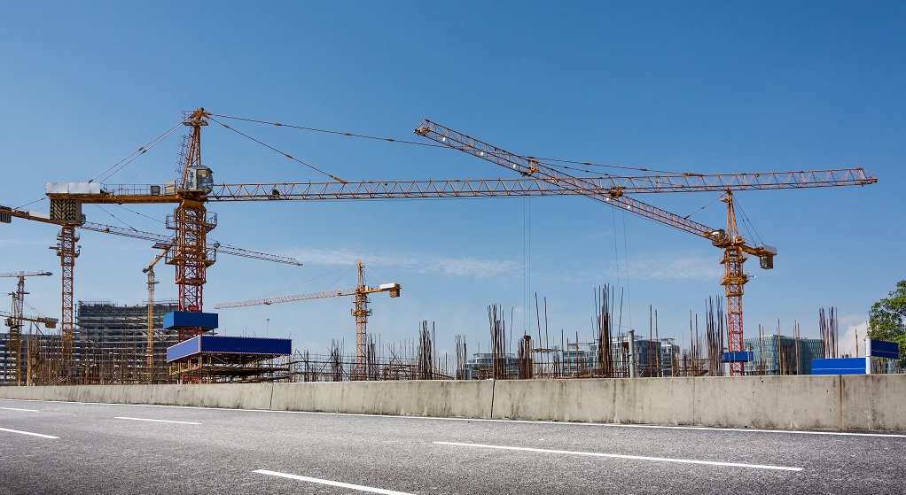 Construction site with cranes against blue sky